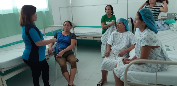 Women listen to a medical worker of Ziga Memorial Hospital prior to ligation